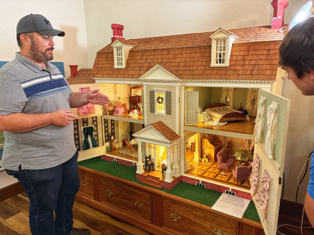 Museum director talking about large doll house.