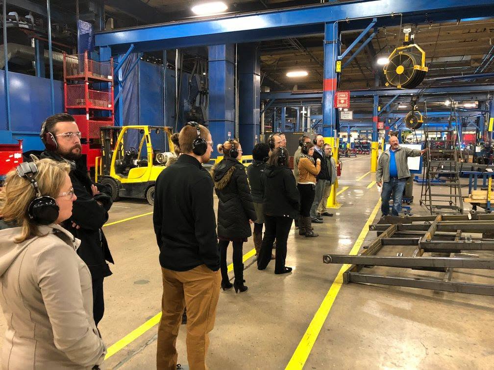 A group of professionals taking a tour through a manufacturing plants.