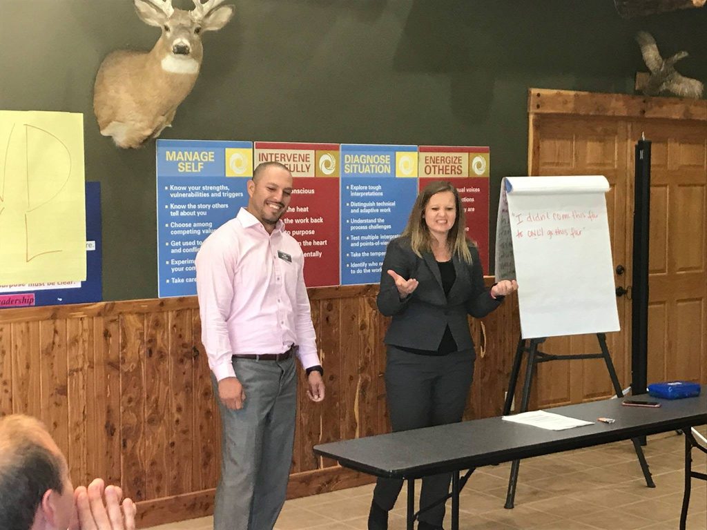 Two professionals laughing and presenting a presentation.